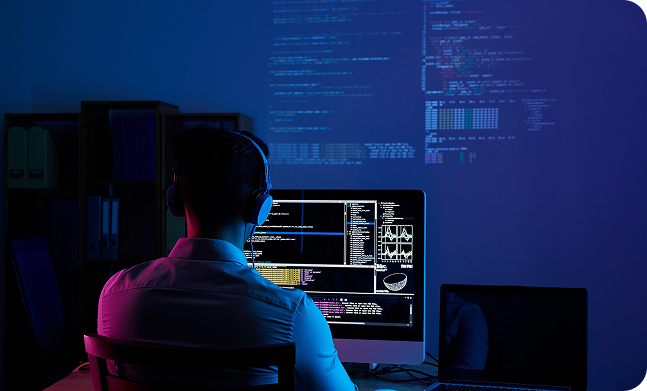 Web developer coding on multiple screens
